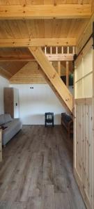 a room with a loft with a bed and wooden ceilings at Domek w Czarnusze in Augustów