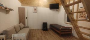 a small living room with a couch and a television at Domek w Czarnusze in Augustów