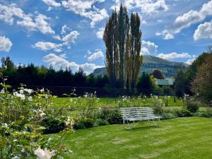 a white bench sitting in the middle of a garden at Autumn Way in Clarens