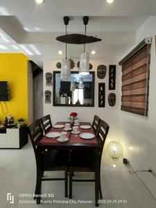 een eetkamer met een tafel, stoelen en een kroonluchter bij Serene Home Stay in Puerto Princesa City +6 foto's