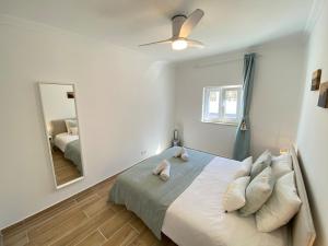 a bedroom with a bed with a ceiling fan and a mirror at Casa do Sol in Sagres