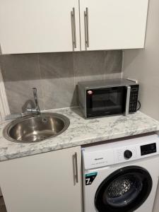 a kitchen counter with a sink and a microwave at Hampstead studio in London