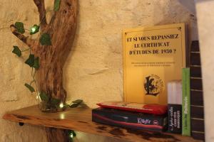 ein Regal mit Büchern und einem Baum darauf in der Unterkunft Studio cosy & ses troglos "Chez Evariste" 