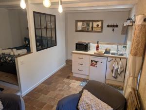 a kitchen with a couch and a sink in a room at Studio cosy & ses troglos "Chez Evariste" in La Tricherie