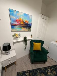 a living room with a green chair and a painting at Hampstead studio in London