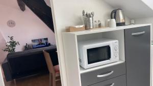 a living room with a tv and a microwave at Studio 3 Apartment with Unique Cathedral View in Meaux