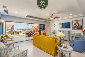 a living room with a yellow couch and a table at 2BR House with Ocean View in Cabo in El Tule