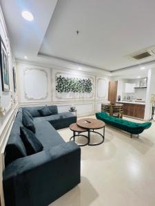a living room with a blue couch and a table at Luxurious Appartment in GOLDCREST DHA Lahore in Lahore