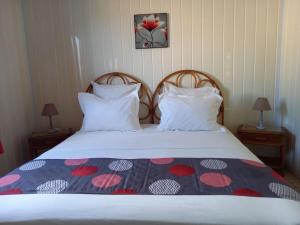 Una cama con dos almohadas y una manta encima. en Résidence les hibiscus 4, en Bouillante