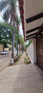 a sidewalk with palm trees on the side of a building at Villa flor in Santa Cruz de la Sierra