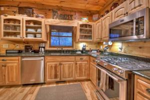 Una cocina con gabinetes de madera y electrodomésticos de acero inoxidable. en Lovely Moterop Chalet, en Morzine 8 fotos más