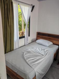 a bed in a room with a window at Casa Caribe in Tortuguero
