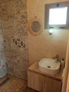 a bathroom with a sink and a window on the wall at Igiwano guest house in Essaouira