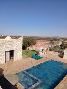 a swimming pool in front of a house at Igiwano guest house in Essaouira +5 photos
