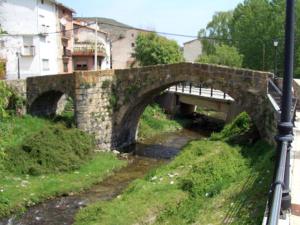 a stone bridge over a river with a bridge at Casa Rural Restaurante Casino Munilla in Munilla +7 photos