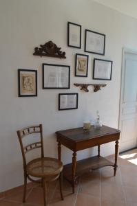 Bassac的住宿－Le Moulin de Bassac，一间设有桌子和椅子的客房,墙上挂有图片