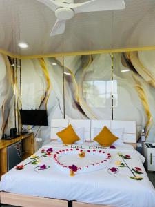 a bed with a heart made out of flowers on it at Fini Palace 