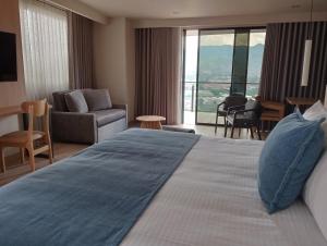 a hotel room with a large bed and a living room at Hotel Rulay Medellin in Medellín