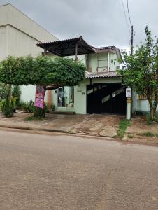 a house with a tree in front of a street at Pousada flores in Porto Velho