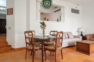 a dining room with a table with chairs and a couch at Amazing 2 BR Condo - Private Terrace - Pool in Puerto Vallarta