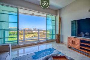 a living room with a large window with a view at Amazing 2BR Condo with Pool and Access to VIDANTA in Jarretadera