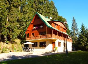 a large wooden house with a green roof at Chalet Tatry in Horná Lehota
