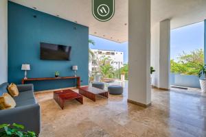 a living room with a couch and a blue wall at Corner 2 BR Condo - Spectacular Oceanview Sunsets in Puerto Vallarta