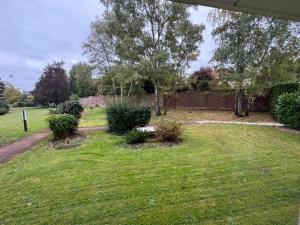 Un patio con una valla y algunos arbustos. en Studio moderne et sécurisé, en Compiègne