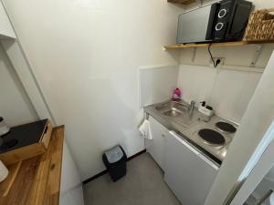 Una pequeña cocina con fregadero y microondas. en Studio moderne et sécurisé, en Compiègne
