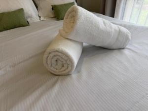 toalla enrollada encima de la cama en Studio moderne et sécurisé, en Compiègne