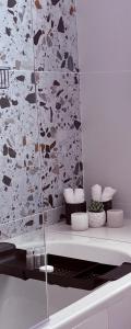 a bathroom with a stone wall and a mirror at Windermere Sands in Gqeberha