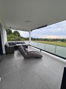 a balcony with a couch and a view of a field at Kuća za odmor Husinec in Husinec