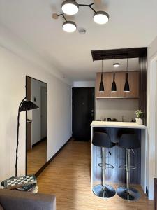 a kitchen with a counter and two stools in a room at D'living Condotel in Davao City