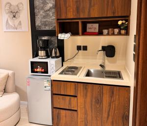 Una pequeña cocina con fregadero y microondas. en استديو انيق بحي السليمانيه, en Riad
