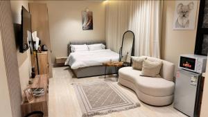 Un dormitorio con una cama, un sofá y una silla. en استديو انيق بحي السليمانيه, en Riad