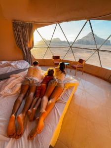 a group of people laying on a bed on a boat at Lunar Mirage Camp in Wadi Rum