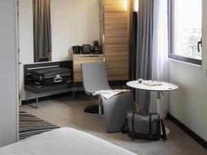 サン・テティエンヌにあるNovotel Saint-Étienne Centre Gare Châteaucreuxのベッド、テーブル、テーブルが備わる客室です。 +112枚の写真