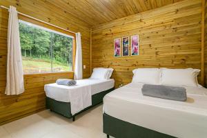 2 Betten in einem Blockhaus mit Fenster in der Unterkunft Altos das Araucárias - one place, great moments! in Alfredo Wagner + 55 Fotos