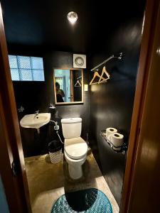 een badkamer met een wit toilet en een wastafel bij Paradiso Hostel Siargao in General Luna +9 foto's