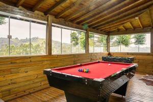 ein roter Billardtisch in einem Raum mit Fenstern in der Unterkunft Altos das Araucárias - one place, great moments! in Alfredo Wagner