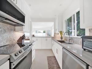 ラグーナ・ビーチにあるLovely Laguna Oceanside Gem!のシンクとコンロのある白いキッチン