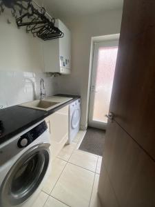 a kitchen with a washing machine and a sink at Manor Park View in Norwich +15 photos