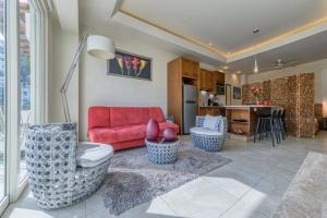 a living room with a red couch and a kitchen at Chic Studio -Rooftop Pool - Ocean View - King Bed in Puerto Vallarta