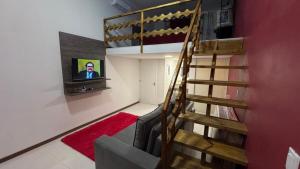 een woonkamer met een trap en een flatscreen-tv bij Loft Firenze - Conforto e Estilo na Serra Gaúcha in Bento Gonçalves