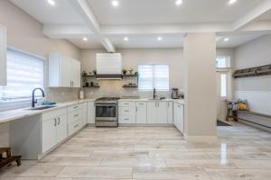a large kitchen with white cabinets and a tile floor at Casa Francesca 6BR Villa & Heated Pool in Roselle +56 photos