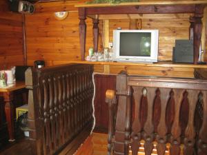 a television sitting on top of a wooden wall at Pie Ozola in Repši