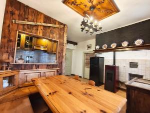 a kitchen with a wooden table in a kitchen at Alma Hunting Lodge in Borca di Cadore