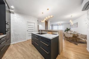 a kitchen with black cabinets and a dining room at Luxury 2BR Apartment - Old Town Bratislava Center in Bratislava