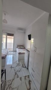 a white room with two beds and a refrigerator at Guesthouse NA in Durrës +25 photos