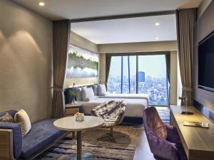 a hotel room with a bed and a large window at Novotel Hanoi Thai Ha in Hanoi